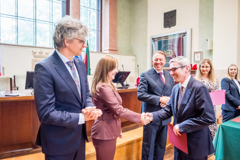 Uczestnicy uroczystości akademickiej podczas składania gratulacji i wręczania wyróżnień.