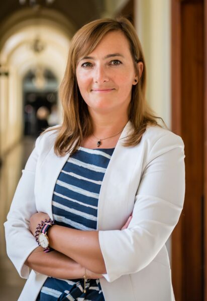 Kobieta w długich włosach, na sobie ma marynarkę