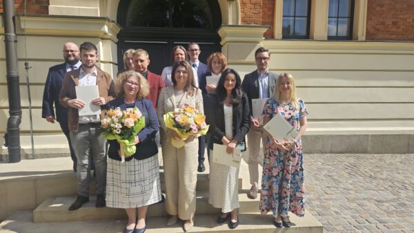 Zdjęcie przed budynkiem Głównym UEK (wejście do Sali Profesorskiej). Na zdjęciu prof. UEK dr hab. Anna Moździerz (Dyrektorem studiów), dr Katarzyna Mikołajczyk (menadżer studiów) oraz uczestnicy studiów.