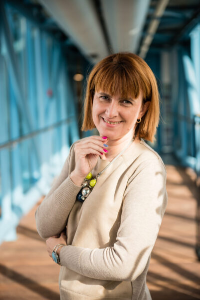 Uśmiechnięta Kobieta, patrząca wprost, w średniej długości włosach